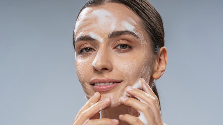 A woman using a foaming facial cleanser